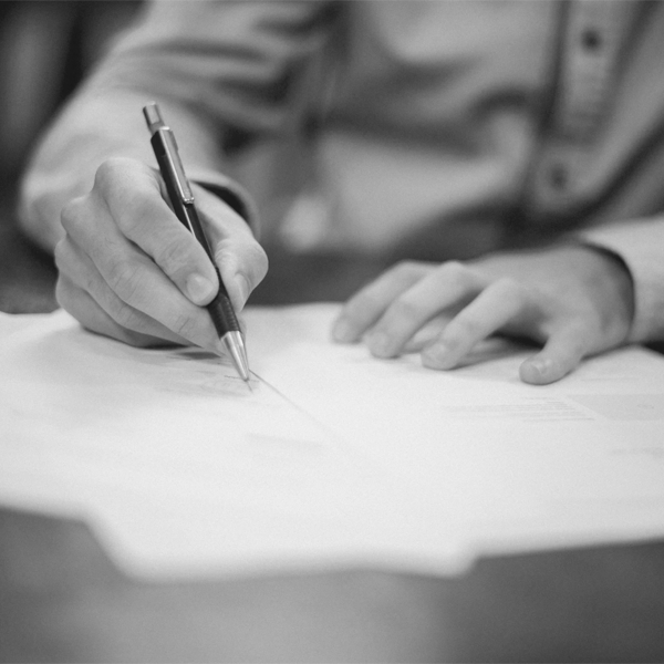 Una mano firma un documento